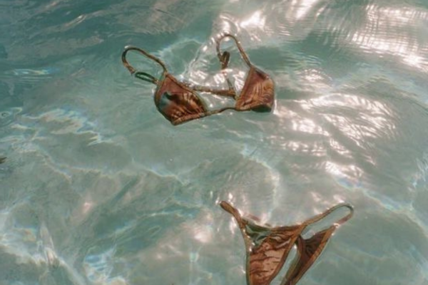 Pool water with a bikini floating, text reads "POOLATES coming soon."