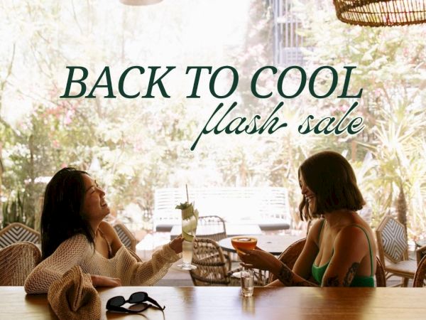 Two people sit outdoors, smiling with drinks, under text: "BACK TO COOL flash sale."